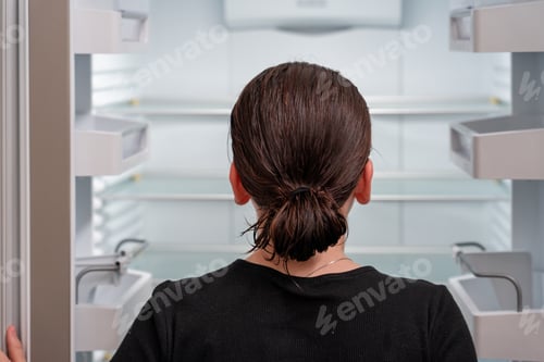 Preview: Close-up Of young girl looking into an empty Refrigerator fridge