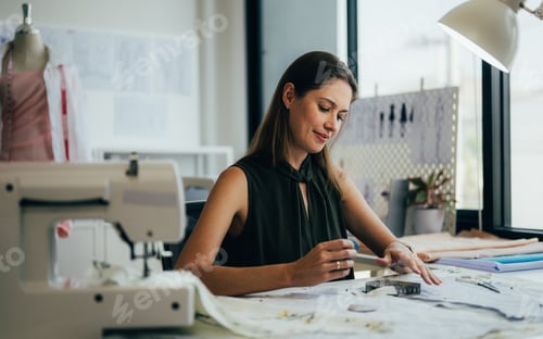 Preview: Beautiful woman dressmaker working in workshop studio