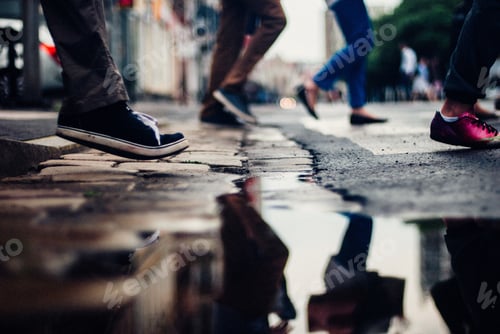 Preview: Puddle with the reflection of a group of people crossing the street
