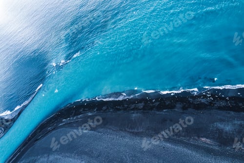 Preview: Dramatic blue sea with ripple wave erosion textured on black sand beach