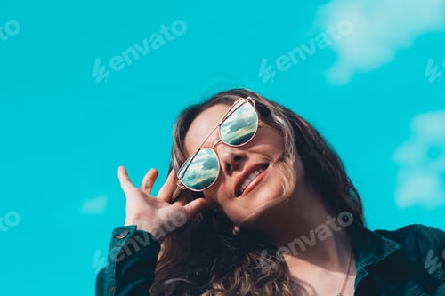 Preview: Smiling Woman in Sunglasses Poses with Blue Sky