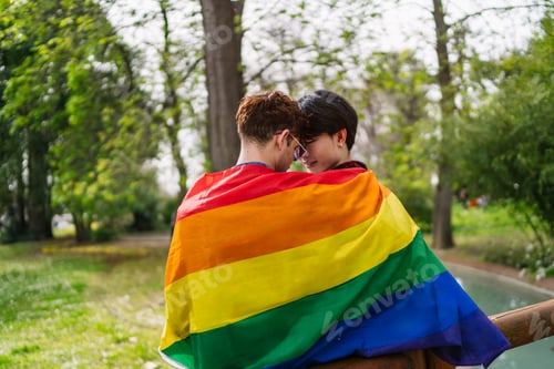Preview: Close-up View of an Interracial Gay Couple Sharing a Moment Under LGBT Flag
