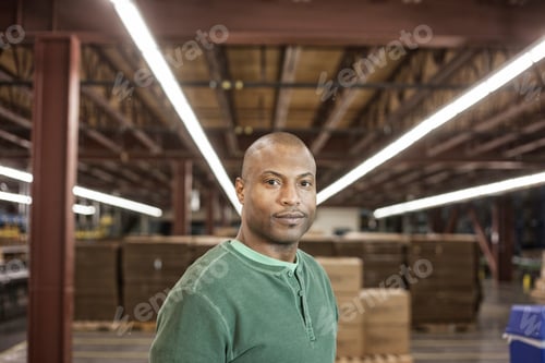 Preview: Working portrait of an African American warehouse worker in a large distribution warehouse.