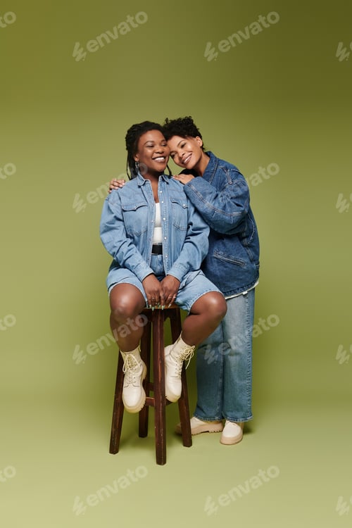 Preview: Loving lesbian couple in stylish outfits sharing a joyful moment indoors