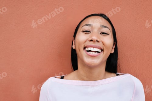 Preview: Young latin woman smiling on camera outdoors in the city - Focus on face