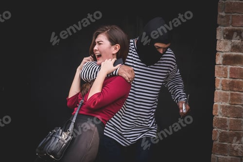 Preview: Thief threatening with knife, young woman scared and screaming while arrested by bandit.