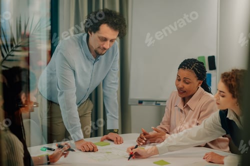 Preview: Diverse team collaborating on blueprint in modern office meeting