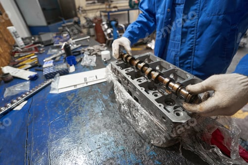 Preview: Man holding metal detail in hands and looking at it