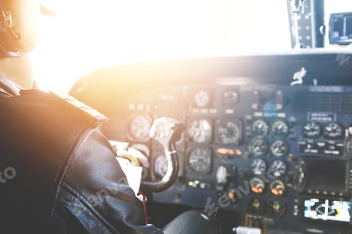 Preview: Caucasian aviator piloting airplane. Rear view of commercial pilot wearing headset and leather jacke