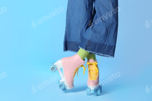 Preview: Woman with vintage roller skates on color background, closeup. Space for text