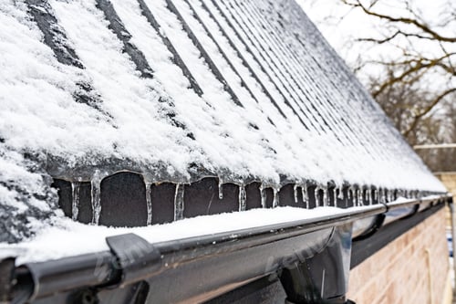 Preview: Frozen icicles on the roof of a country house