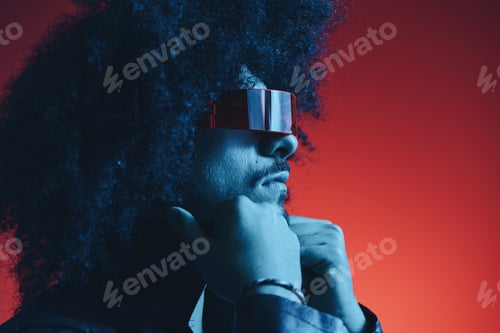 Preview: Portrait of fashion man with curly hair on red background with stylish glasses, multicultural