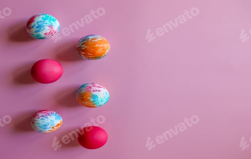 Preview: Happy Easter holiday! Colorful hand-painted Easter eggs on pink background. Copy space