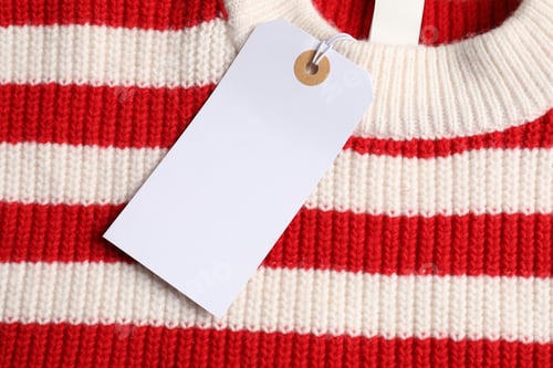 Preview: Cardboard tag on knitted sweater, top view
