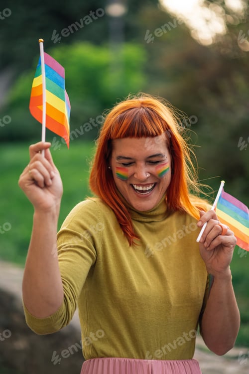 Preview: Happy activist holding rainbow flags celebrating lgbtq plus pride in park