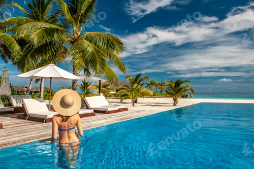 Preview: Woman with hat at beach pool in Maldives