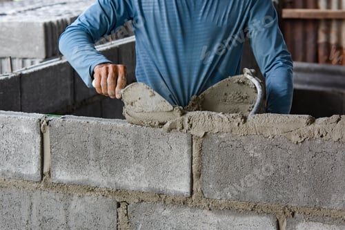 Preview: Bricklayer laying bricks on mortar