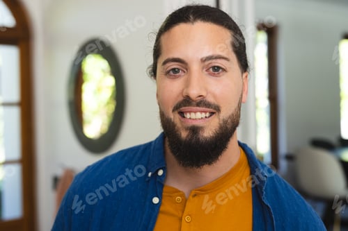 Preview: Portrait of happy caucasian man with beard standing and smiling in sunny house