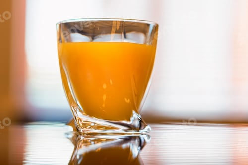 Preview: Glass of fresh orange juice on a wooden table close