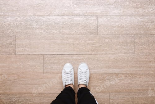 Preview: Selfie of feet in fashion sneakers on wooden floor background, top view with copy space