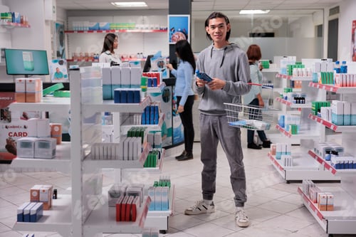 Preview: Smiling asian man buying pills bottle