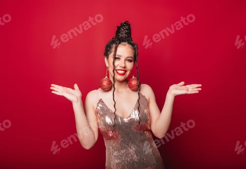 Preview: a woman with dark hair with Christmas balls on her ears.