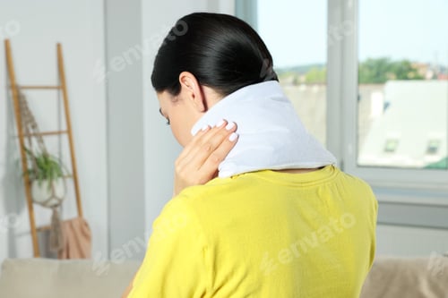 Preview: Woman using heating pad on neck at home