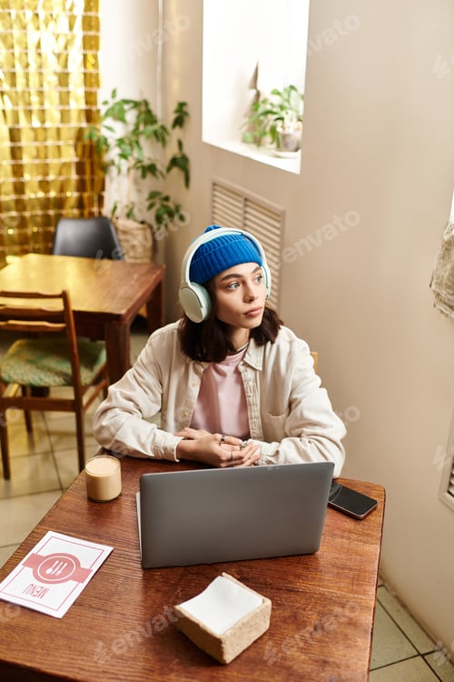 Preview: Young woman immersed in remote work at a cozy cafe during a sunny afternoon