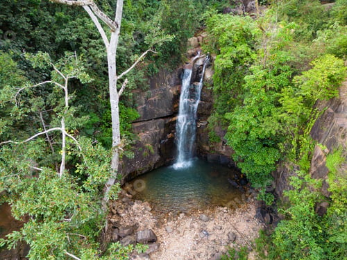 Preview: Drone view of Veal Puch Waterfall surrounded by greenery in Kampot, Cambodia