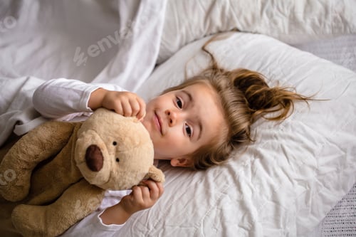 Preview: little girl in bed with soft toy the emotions of a child