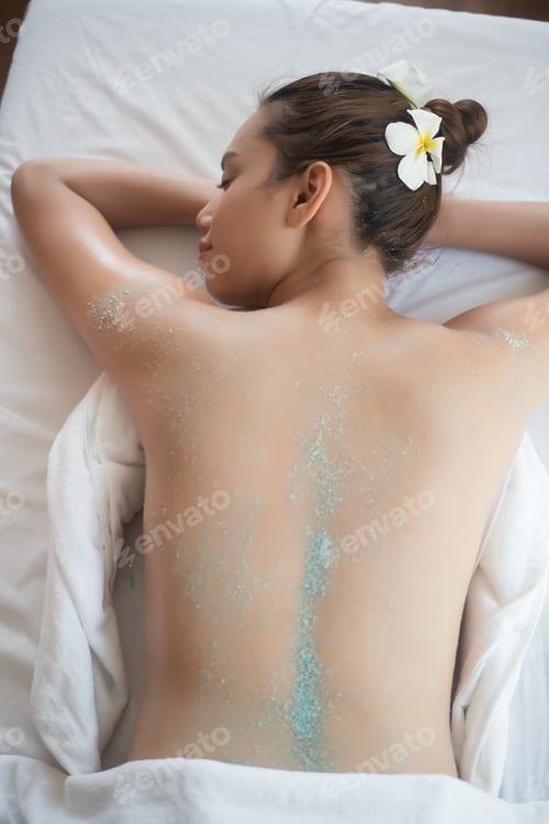 Preview: Beautiful woman getting a salt scrub beauty treatment in the health spa.