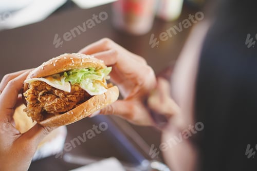 Preview: tasty burger. stylish hipster woman holding juicy hamburger in hands close up.