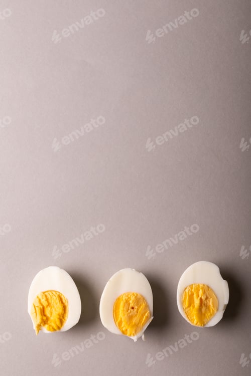 Preview: Overhead view of copy space with fresh boiled white egg halves against gray background