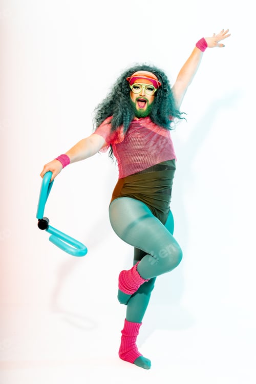 Preview: Excited man in drag queen costumes dancing in studio with thigh master