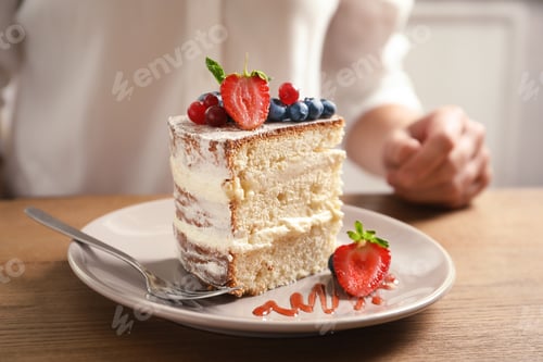 Preview: Piece of delicious homemade cake with fresh berries and blurred woman on background