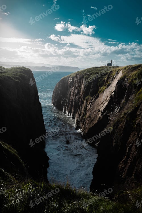 Preview: Vertical aerial shot of cliffs with the sea on the background under the sunlight