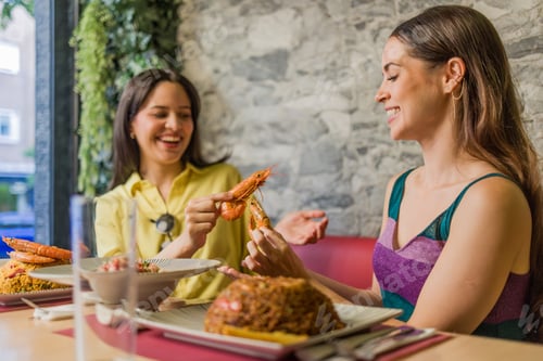 Preview: Women eating shrimps in ecuadorian restaurant in madrid