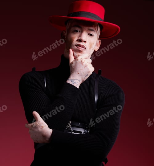 Preview: Man, fashion style or vitiligo skin on red background studio in empowerment, self love or attitude.