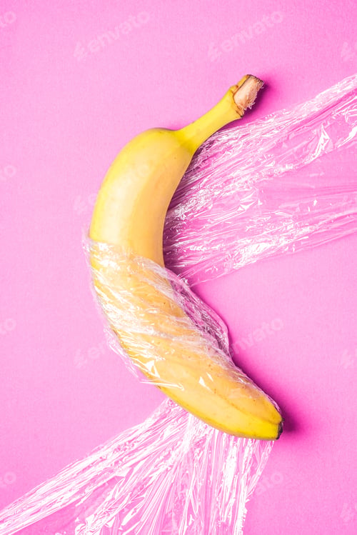 Preview: Banana fruit wrapped in stretch wrap plastic on pink background