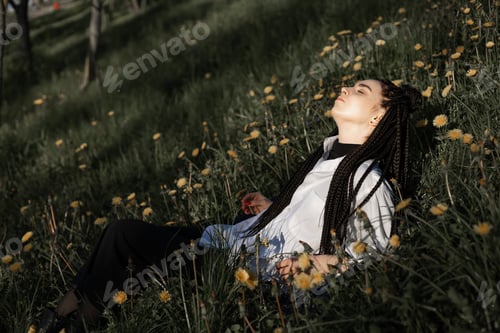 Preview: Relaxing woman lying on spring blooming meadow. Girl resting in summer park. Enjoy life, having fun,