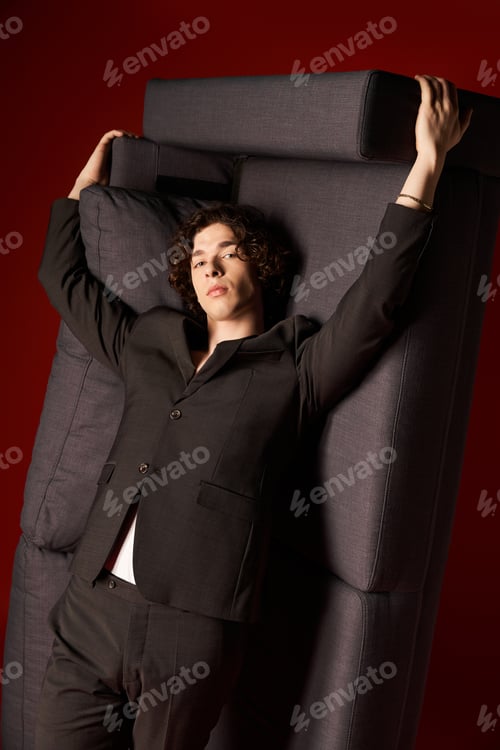 Preview: Curly haired young man striking a stylish pose in a modern studio setting