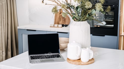 Preview: Home Office Setup with Laptop and Cozy Kitchen Decor. A chic home office setup featuring an open
