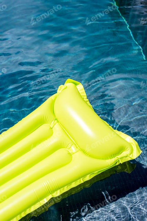 Preview: close-up shot of green inflatable mattress floating in swimming pool