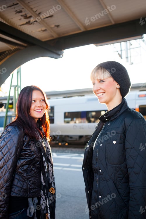 Preview: Beautiful happy women standing railroad station