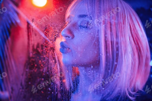 Preview: Sensual look. Stylish woman with white hair is behind wet transparent plastic sheet