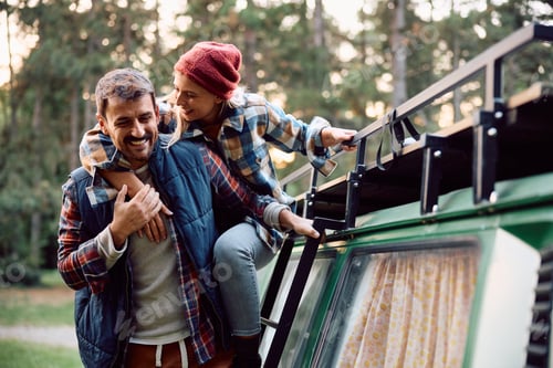 Preview: Carefree couple having fun together while camping in nature in autumn.
