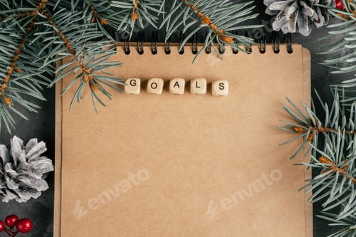 Preview: Open brown kraft paper folded notebook with Goals written on wooden cubes. Christmas and New Year