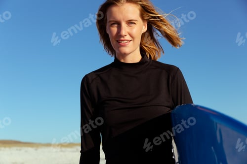 Preview: Portrait of woman with surfboard at the beach