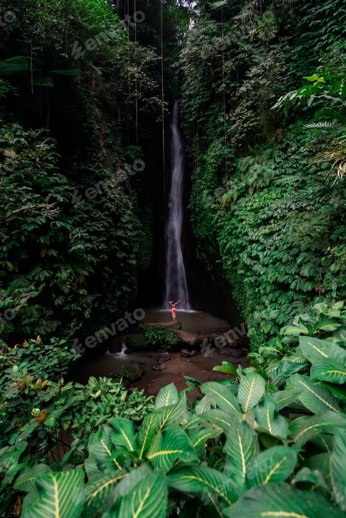 Preview: Young female tourism enjoying the Leke Leke waterfall at Bali in Indonesia