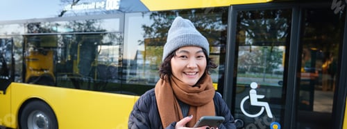 Preview: Woman Smiling Near a Yellow Public Transportation Bus